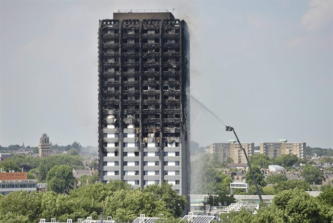 Firefighters spray water onto the 24-storey apartment block in west London.