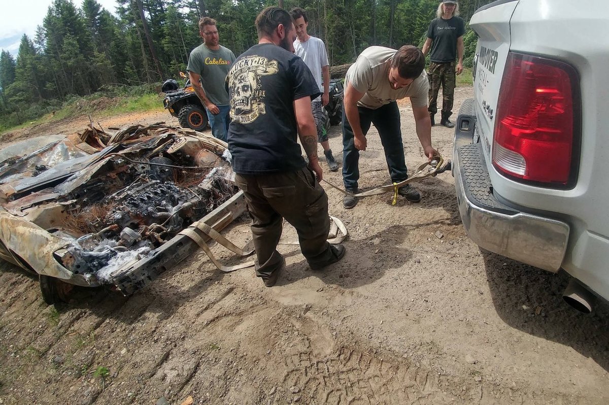 OFTF volunteers haul a burnt out vehicle from the woods near Kelowna.