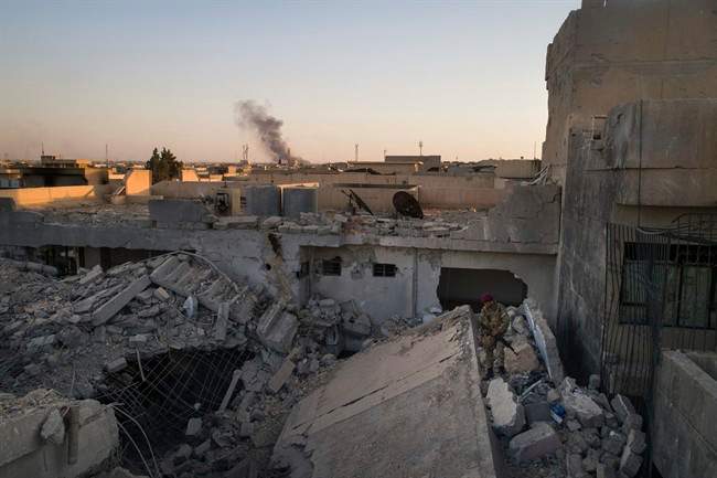 An Iraqi soldier stands atop a destroyed house in a neighborhood recently retaken by Iraqi security forces during fighting against Islamic State militants in west Mosul, Iraq, Sunday, June 25, 2017. 