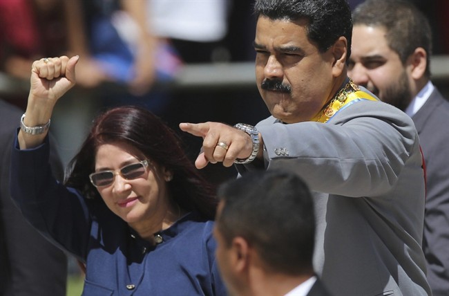 Venezuela's President Nicolas Maduro, right, and first lady Cilia Flores greet supporters upon arrival to a military parade at Fort Tiuna in Caracas, Venezuela.
