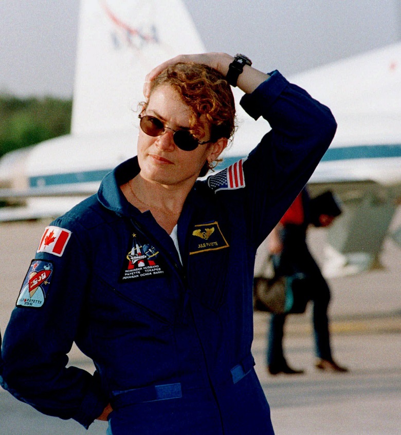 Julie Payette holds onto her hair as the wind gusts at the Kennedy Space Center, Fla., in April 26, 1999.