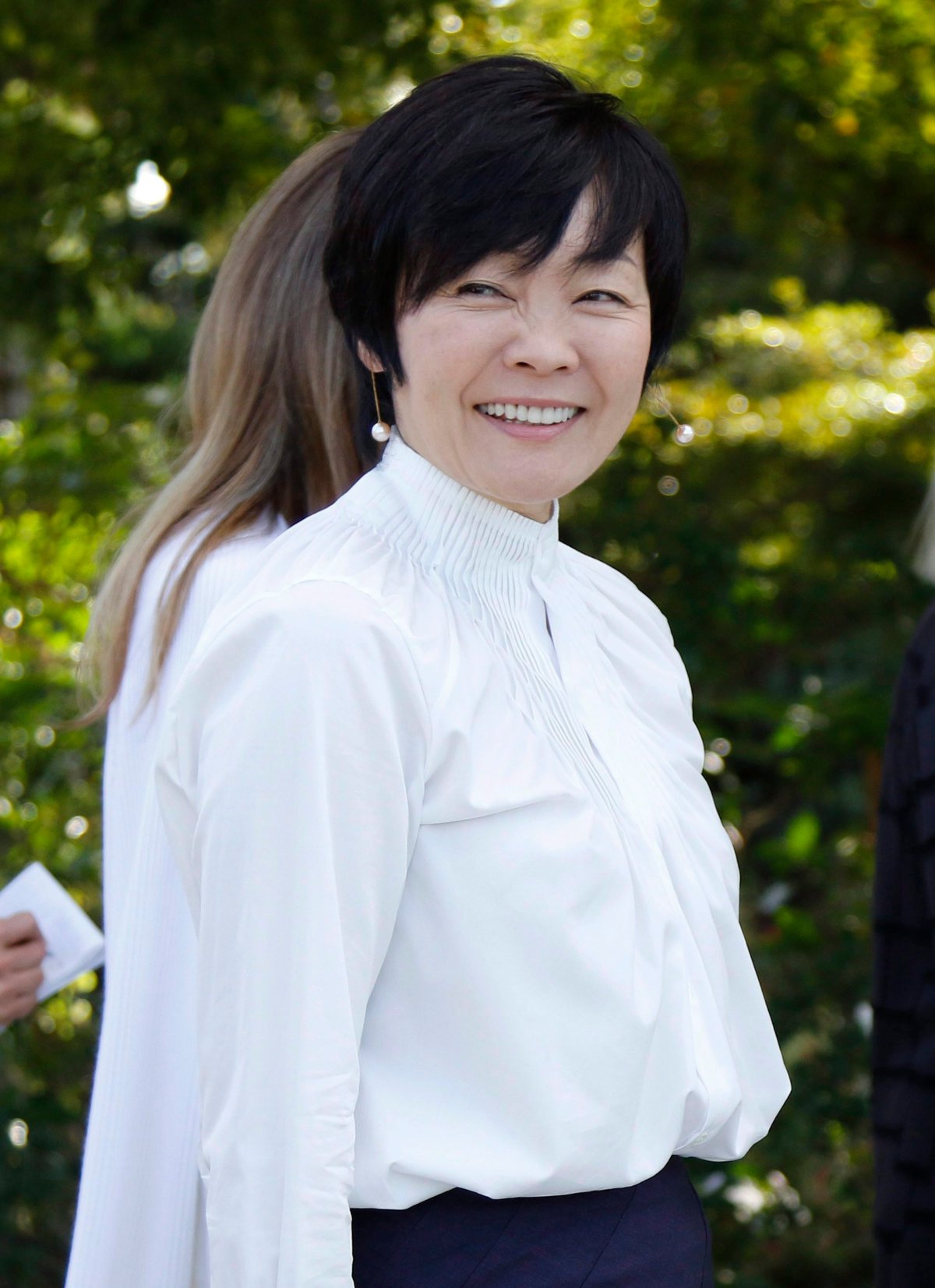 Akie Abe, wife of Japanese Prime Minister Shinzo Abe, smiles as she walks by the media during a tour of Morikami Museum and Japanese Gardens in Delray Beach, Fla., on Saturday, Feb. 11, 2017. 
