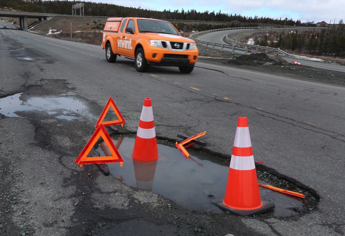 A vehicle drives by multiple potholes along the Team Gushue Highway in St. John's on Wednesday, March 22, 2017.