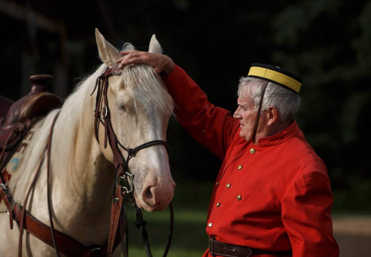 Retired RCMP Sergeant Malcom Eskelson prepares his horse during a re-enactment of the March West, near Fort Saskatchewan, Alta., on June 30, 2017.