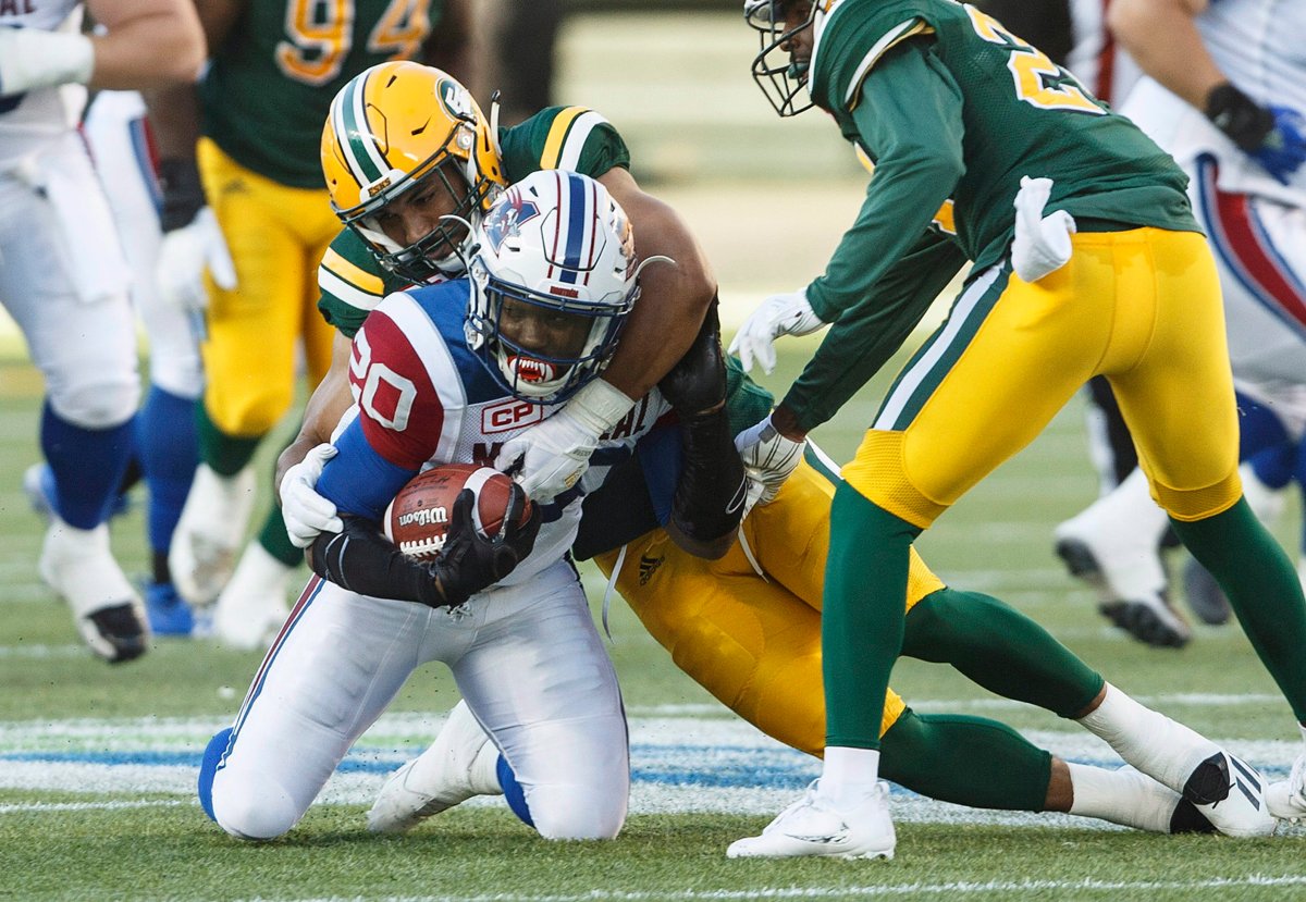 Montreal Alouettes' Tyrell Sutton (20) is tackled by Edmonton Eskimos' Korey Jones (45) during first half CFL action in Edmonton on Friday, June 30, 2017.