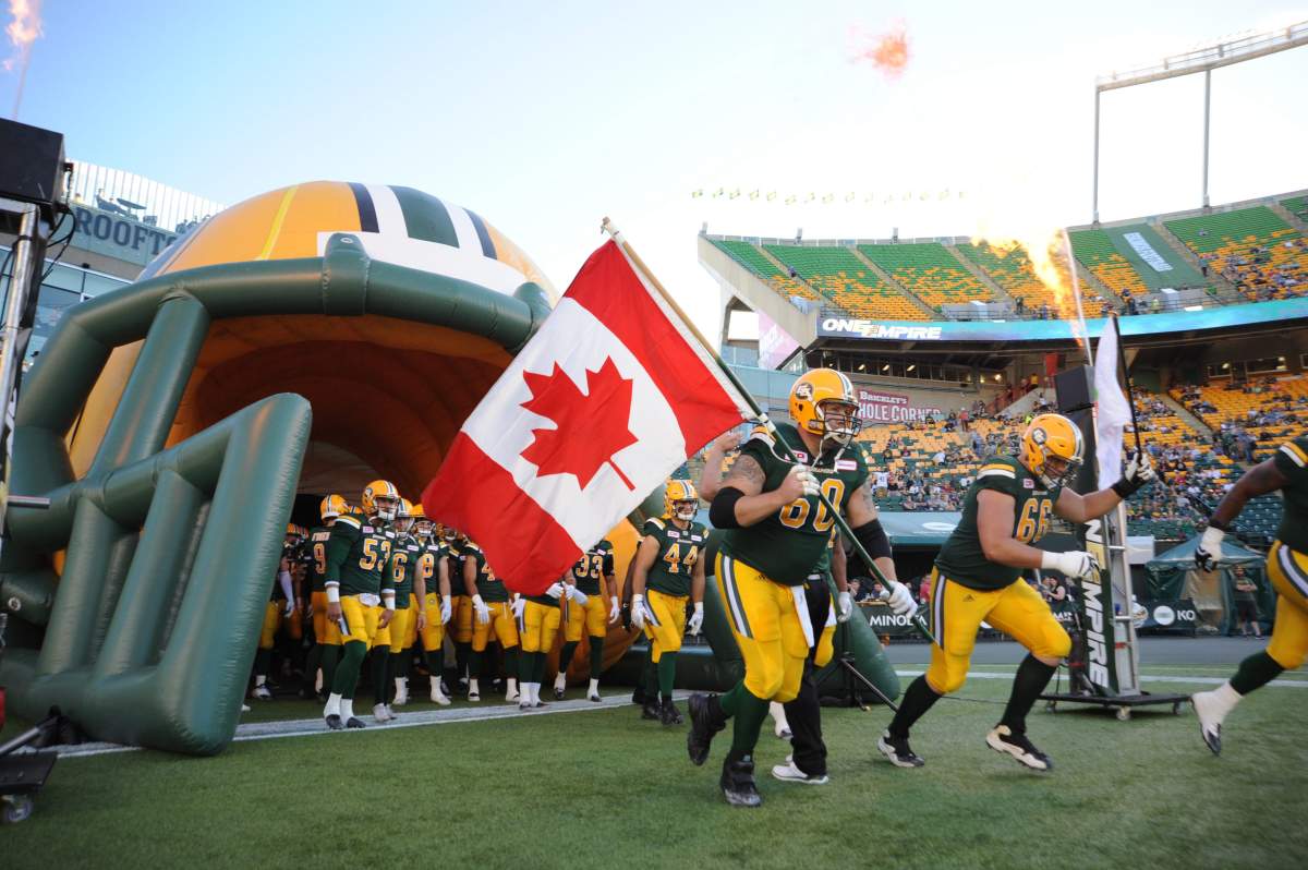 Edmonton Eskimos player #60 (OL) Justin Sorensen with player # 66 (OL) Matt O'Donnell run out onto the field before the first quarter of CFL game action between the Edmonton Eskimo's and the Montreal Alouettes at the Brick Field located at Commonwealth stadium in Edmonton Friday, June 30/2017.  (CFL PHOTO Walter Tychnowicz- ).
