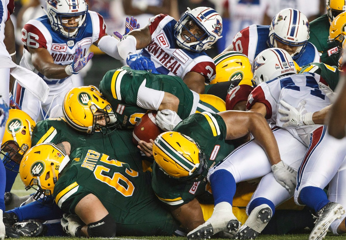 Edmonton Eskimos quarterback Mike Reilly (13) dives in for the first down during second half CFL action against the Montreal Alouettes, in Edmonton on Friday, June 30, 2017.