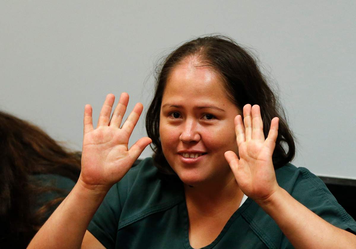 Isabel Martinez gestures towards news cameras during her first court appearance Friday, July 7, 2017, in Lawrenceville, Ga.