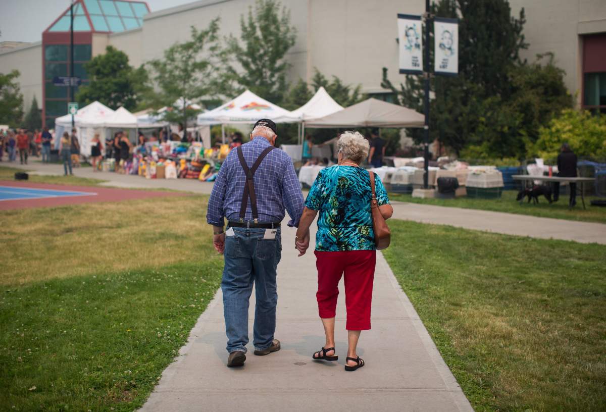 Wildfire evacuees McLean Rislund, 80, and June Rislund, 81, from Forest Grove near 100 Mile House, walk to an evacuation registration centre in Kamloops, B.C., on Monday July 10, 2017. More than 200 wildfires are burning in the province and an estimated 14,000 people have been evacuated from their homes. THE CANADIAN PRESS/Darryl Dyck