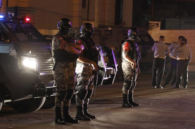Jordanian security forces stand infront of their armored vehicle next to the Israel embassy, in Amman, Jordan, July 23, 2017. 