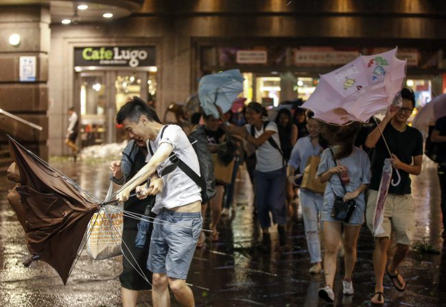 People shield themselves from strong wind and rain brought by Typhoon Nesat in Taipei, Taiwan, 29 July 2017. 