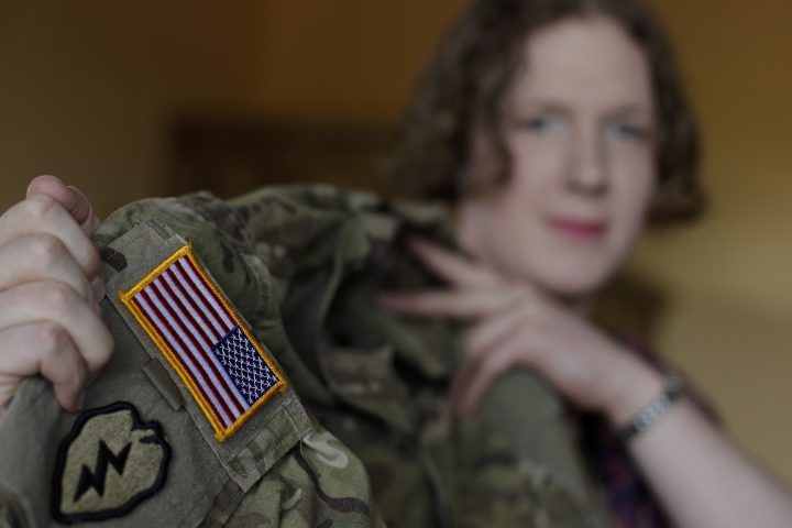 In this July 29, 2017 photo transgender U.S. army captain  Jennifer Sims lifts her uniform during an interview with The Associated Press in Beratzhausen near Regensburg, Germany.  
