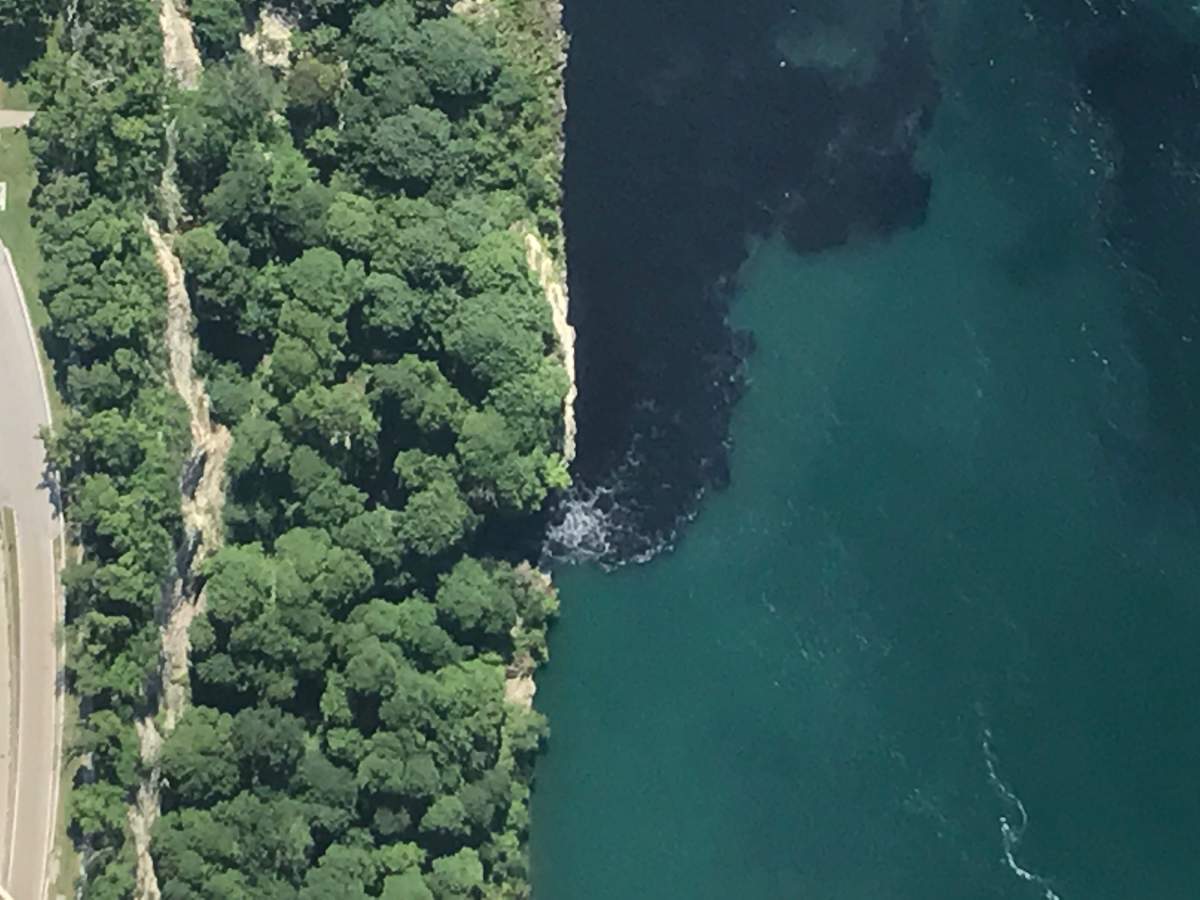 The water near the base of the falls that border the U.S. and Canada turned an alarming shade of black before tourists’ eyes following a foul-smelling discharge from a nearby wastewater treatment plant. The water board for the city says Saturday’s discharge was part of routine maintenance of one of its basins, that the discharge was within permitted limits and had dissipated by Sunday. (Patrick J. Proctor/Rainbow Air INC. via AP)
