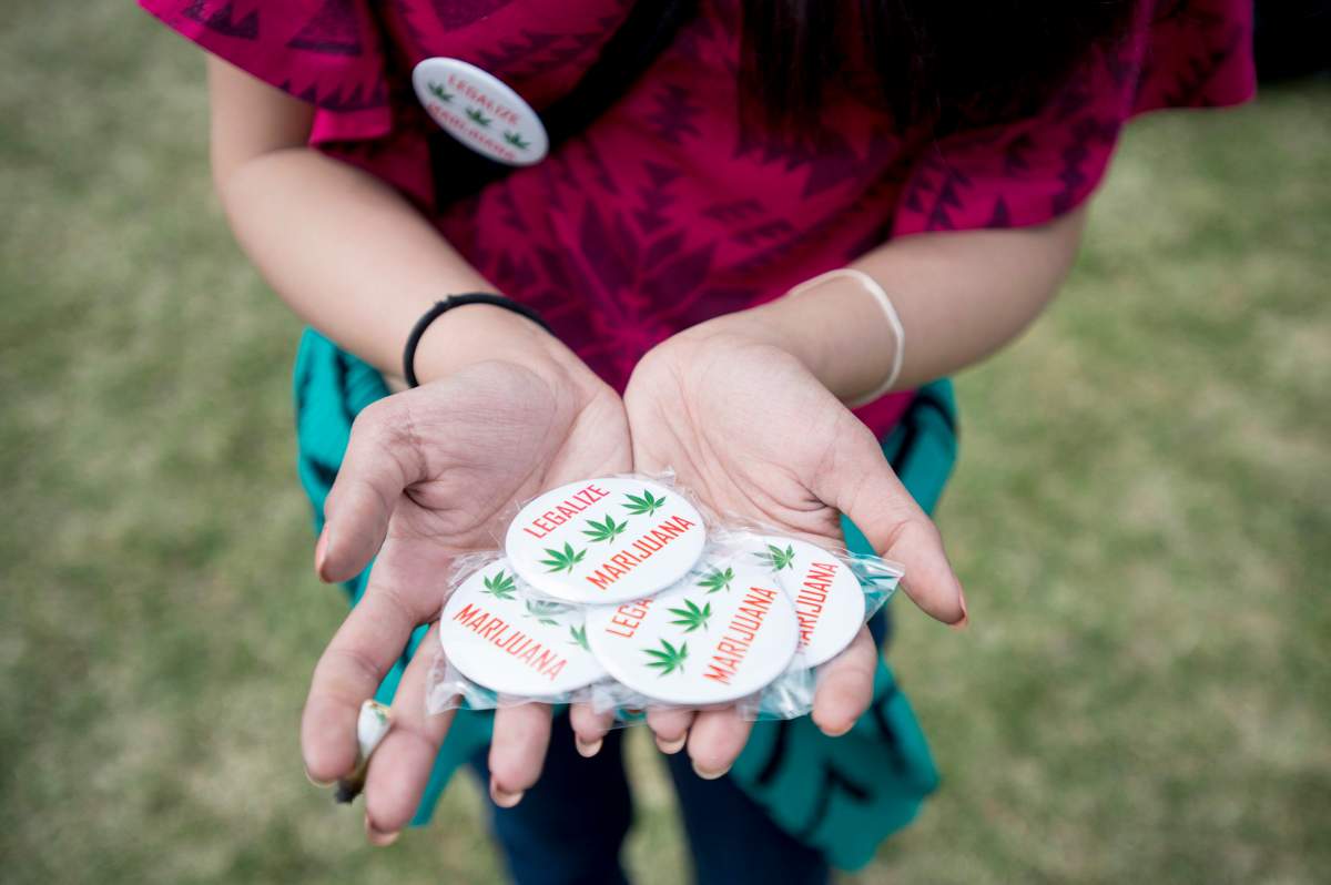 A woman holds pins supporting the legalization of marijuana at the Fill the Hill marijuana rally on Parliament Hill in Ottawa on Sunday, April 20, 2014. THE CANADIAN PRESS/Justin Tang.