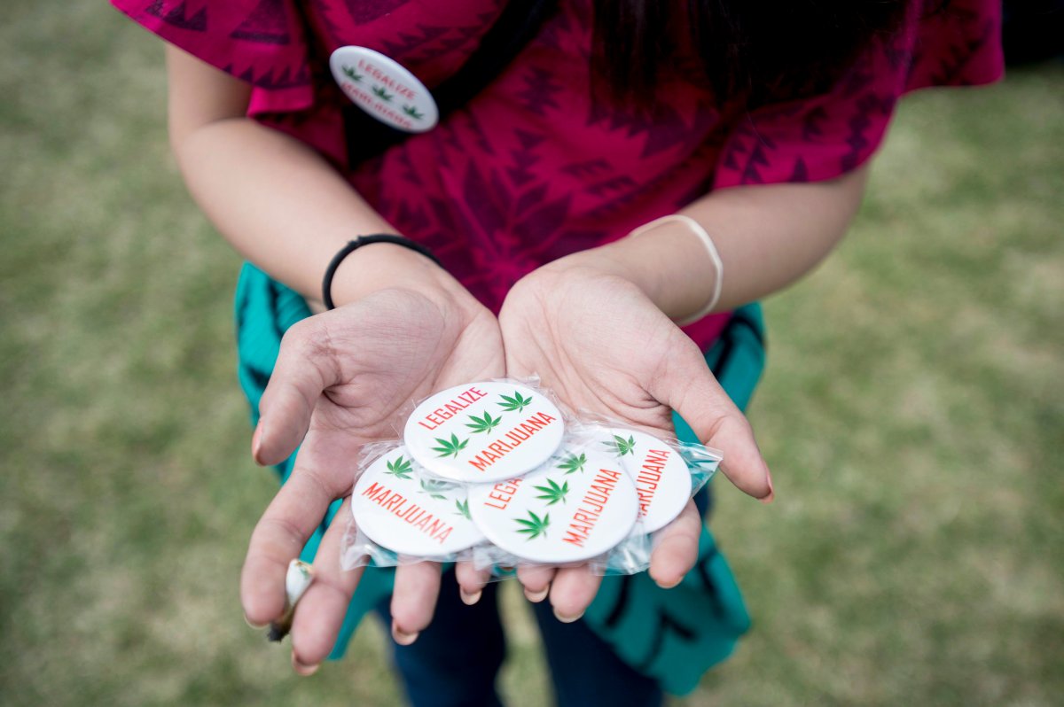 A woman holds pins supporting the legalization of marijuana at the Fill the Hill marijuana rally on Parliament Hill in Ottawa on Sunday, April 20, 2014. THE CANADIAN PRESS/Justin Tang.