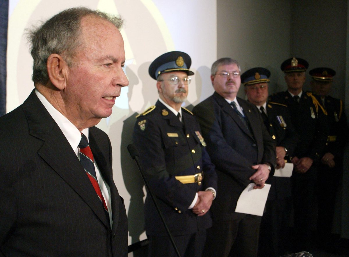 Ontario Minister of Community Safety and Correctional Services Monte Kwinter (left) is flanked by senior police officers at a news conference in Toronto on Tuesday Feb. 15, 2005. 