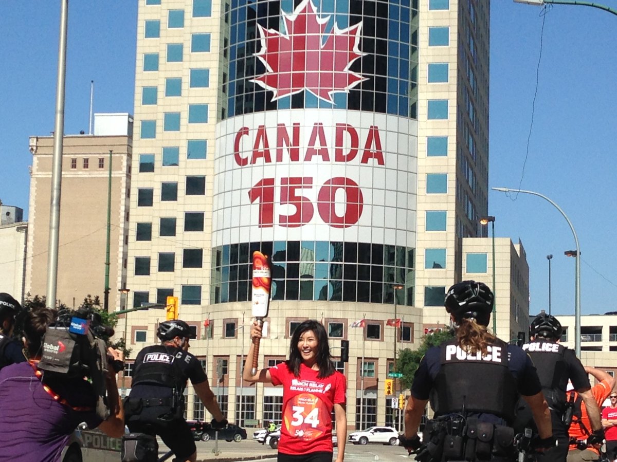 Global's Adriana Zhang carries the torch through downtown Winnipeg Wednesday morning. 