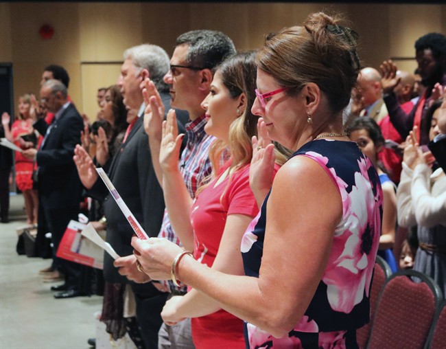People take the citizenship oath at Pier 21 immigration centre in Halifax on Saturday, July 1, 2017. 