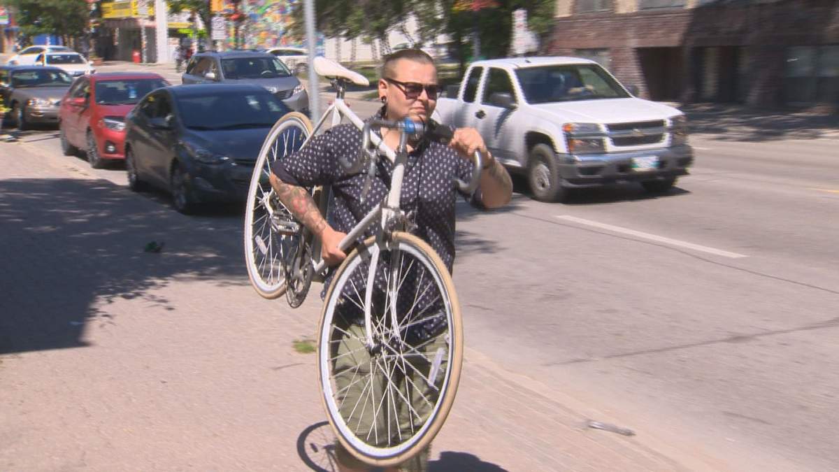 April Ludwick carries her bike after it was damaged in a road rage incident.