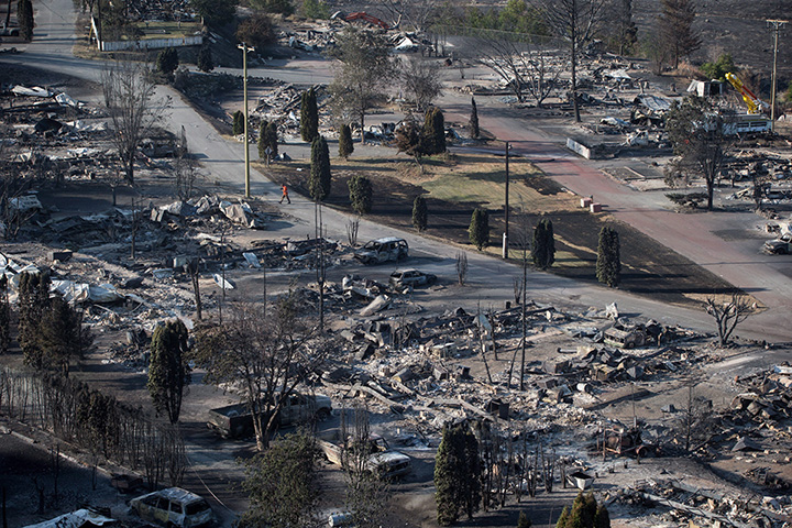 B.C. Hydro workers repair power lines among the remains of mobile homes destroyed by wildfire in Boston Flats near Ashcroft on Sunday July 9, 2017.