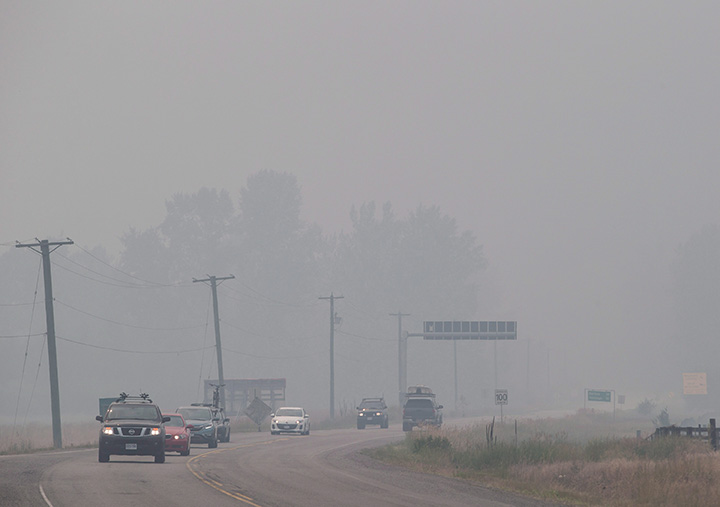 Smoke from wildfires blankets the area as motorists travel on the Yellowhead Highway in Little Fort, B.C., on Saturday July 8, 2017.