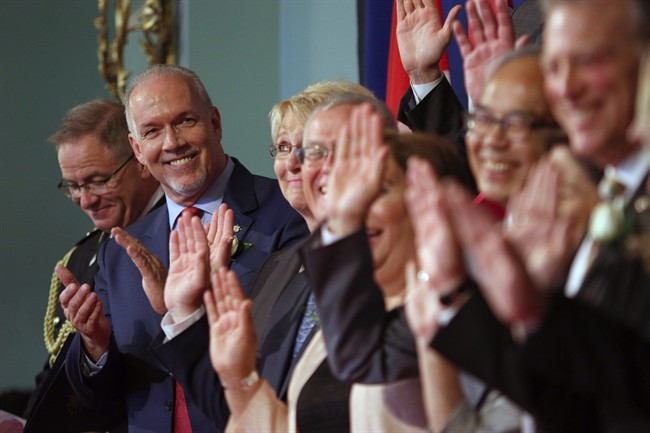 Premier John Horgan smiles at cabinet members after being sworn-in as Premier during a ceremony with his provincial cabinet at Government House in Victoria, B.C., on Tuesday, July 18, 2017. 