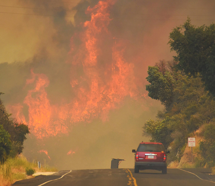 A Santa Barbara City Fire vehicle drives towards flames from the Whittier Fire east of Cachuma Lake near Santa Barbara, California on July 8, 2017.