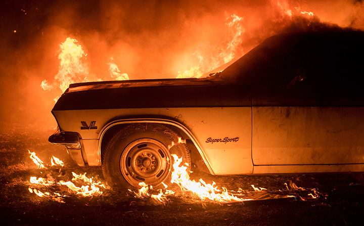 Flames from a wildfire consume a car near Oroville, Calif., on Saturday, July 8, 2017.