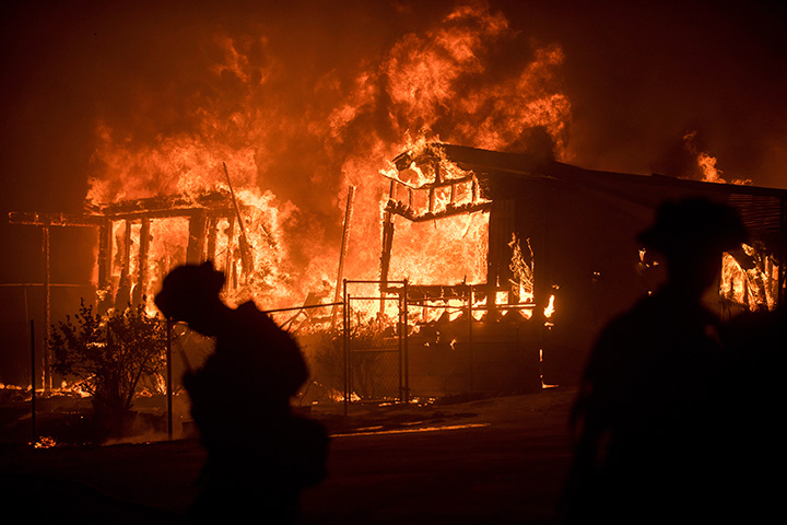 Flames from a wildfire consume a residence near Oroville, Calif., on Sunday, July 9, 2017.