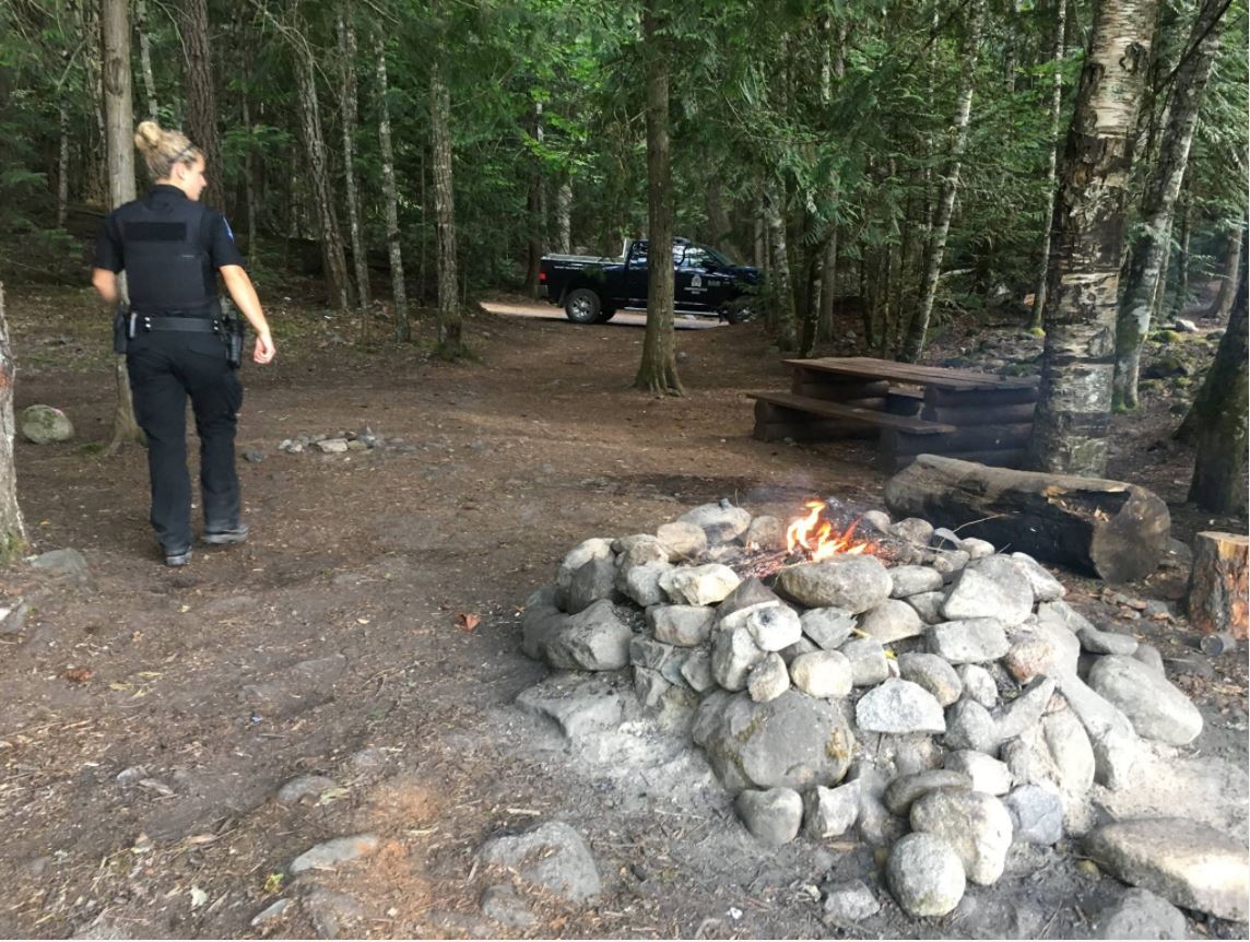 A B.C. Conservation Service officer deals with an illegal campfire.