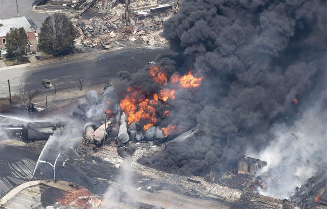 Smoke rises from railway cars that were carrying crude oil after derailing in downtown Lac-Megantic, Que., on July 6, 2013. The dangers of transporting hazardous goods by train were highlighted in tragic fashion four years ago, when an oil-laden runaway train derailed and crashed in the centre of Lac-Megantic, Que., killing 47 people. 