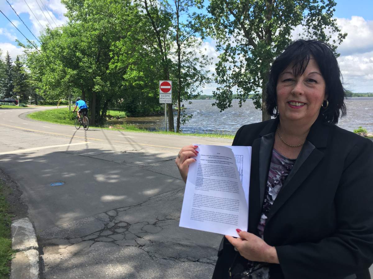 Carmen Pilotte holds a petition to revert the multi-purpose path on Duhamel Road in Pincourt, Monday July 3, 2017.