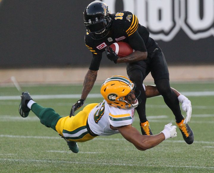 Edmonton Eskimos defensive back Andrew Lue (19) dives to reach Hamilton Tiger-Cats wide receiver Brandon Banks (16) on a punt return during first half CFL football action in Hamilton, Ont. on Thursday, July 20, 2017. 
