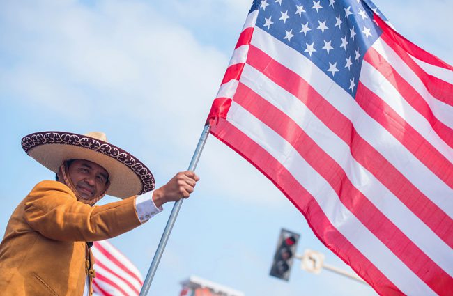 A parade attendee carries a flag at the 112th Annual Huntington Beach 4th of July Parade on July 4, 2016 in Huntington Beach, California.