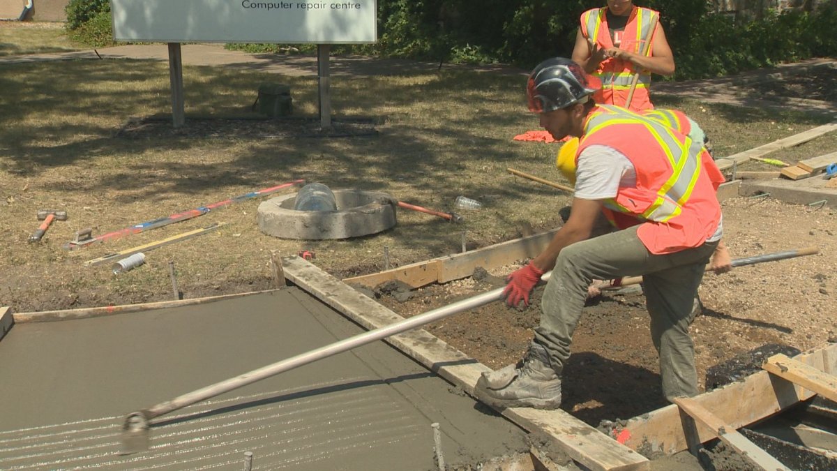 Construction workers in Regina try to push through the heat to get the job done.