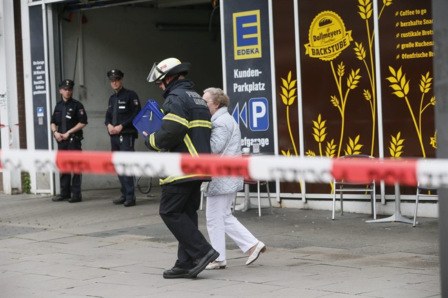 An elderly woman is accompanied by a firefighter after a knife attack at a supermarket in Hamburg, Germany, 28 July 2017.