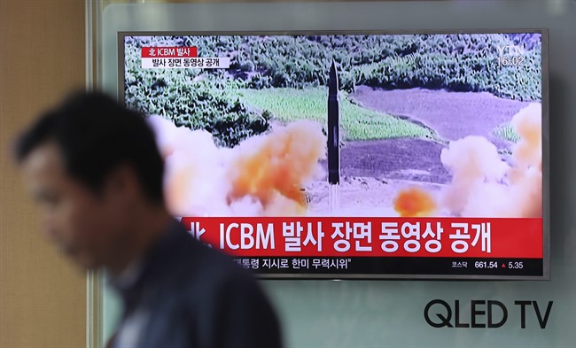 A man walks by a TV screen showing a local news program reporting about North Korea's missile firing at Seoul Train Station in Seoul, South Korea, Wednesday, July 5, 2017. 