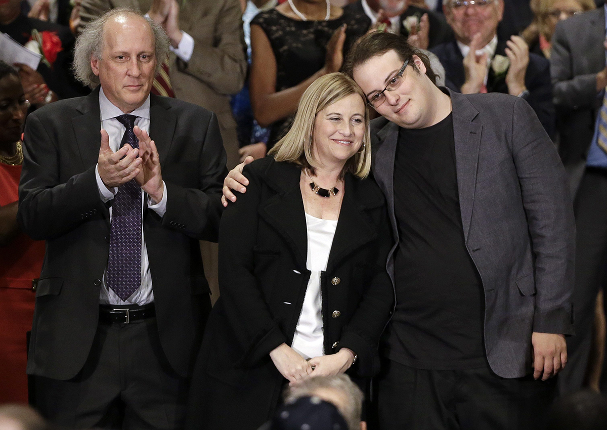  In this Sept. 25, 2015, photo, Nashville Mayor Megan Barry, center, is hugged by her son, Max, as her husband, Bruce, left, applauds after she was sworn into office in Nashville, Tenn. 