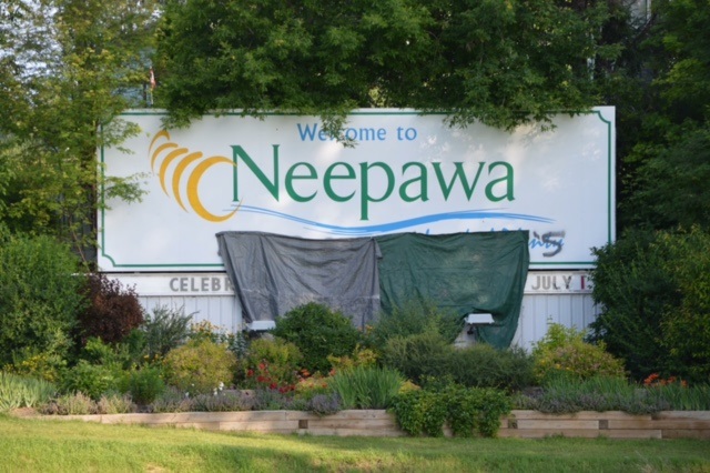A tarp covers racist graffiti sprayed on a sign welcoming visitors to Neepawa. 