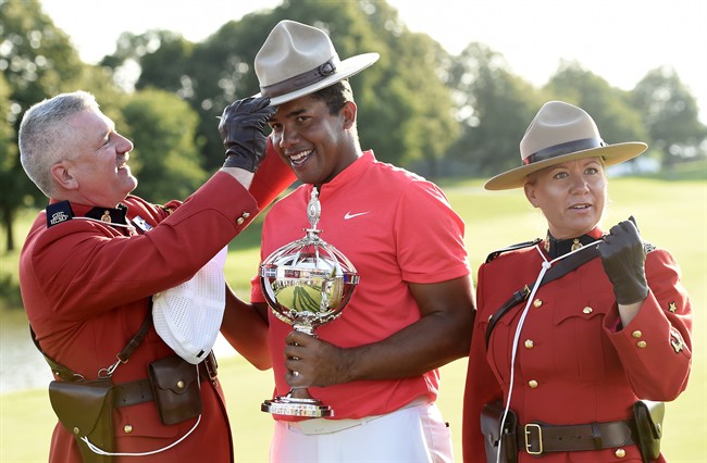 Jhonattan Vegas holds the winner's trophy as he tries on a Mountie stetson following his win at the final round of the 2017 Canadian Open at the Glen Abbey Golf Club in Oakville, Ont., on Sunday, July 30, 2017. 
