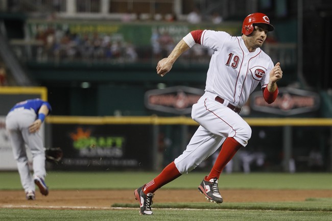 Cincinnati Reds' Joey Votto (19) runs home to score after stealing third against Chicago Cubs third baseman Tommy La Stella, left, in the eighth inning of a baseball game, Friday, June 30, 2017, in Cincinnati.