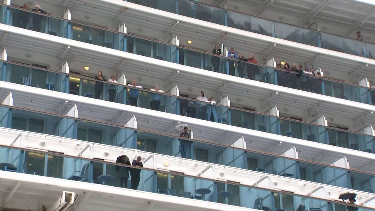 Passengers onboard the Emerald Princess cruise ship look from their cabin decks as FBI agents investigated a death on the boat.