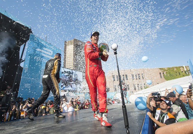 ABT Schaeffler FE02 driver Lucas Di Grassi, of Brazil, sprays champagne on the crowd after winning at the Montreal Formula ePrix electric car race, in Montreal on Saturday, July 29, 2017. 