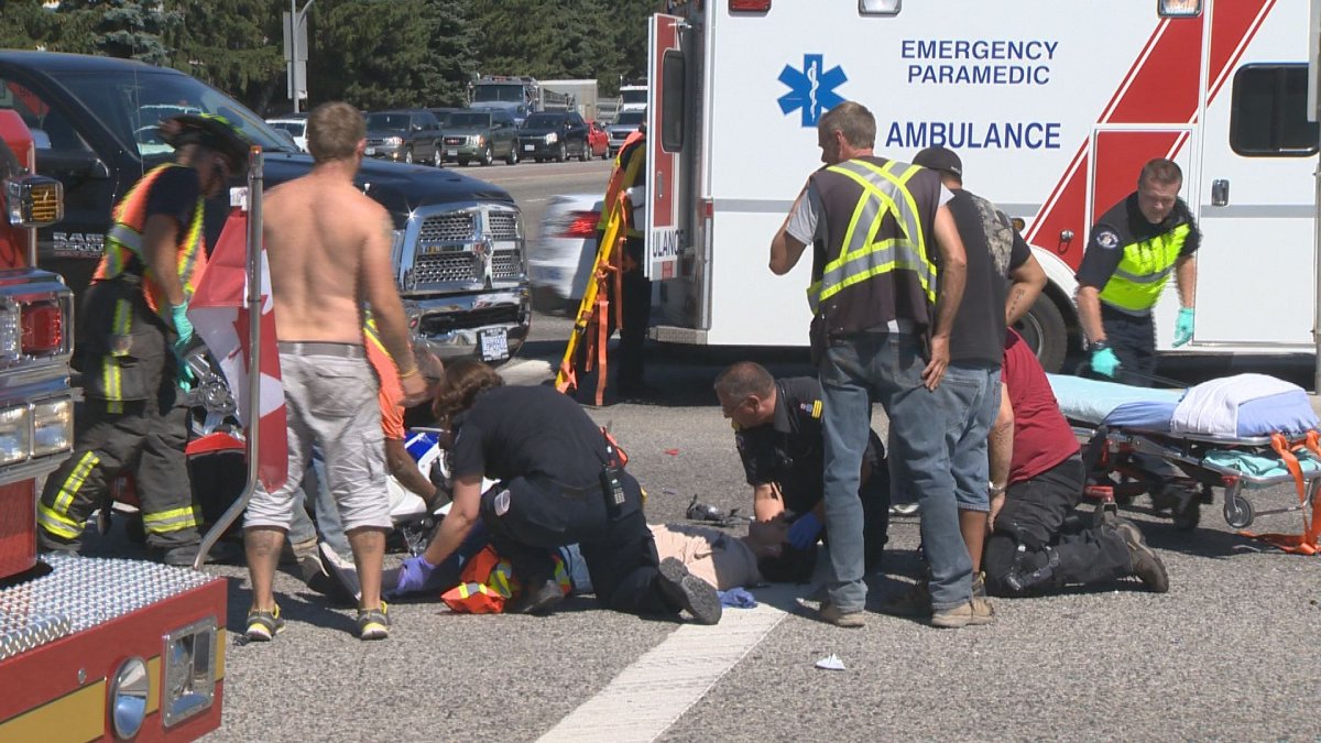 Ambulance paramedics attend to an injured motorcyclist Friday in Kelowna.