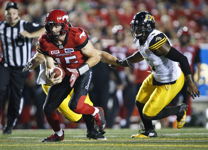 Hamilton Tiger-Cats defensive end Adrian Tracy, right, chases Calgary Stampeders quarterback Andrew Buckley during second half CFL football action in Calgary, Saturday, July 29, 2017. 