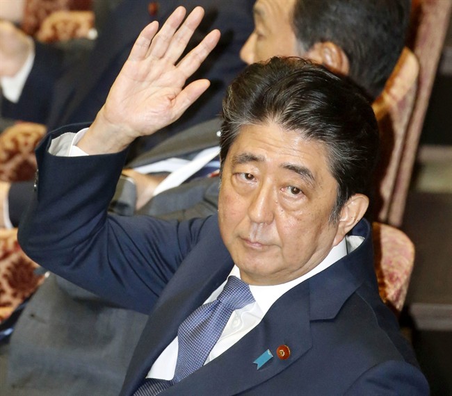 Japanese Prime Minister Shinzo Abe raises hand before speaking during a session of the House of Representatives Budget Committee in Tokyo Monday, July 24, 2017. 