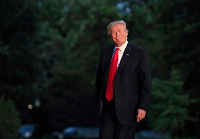 President Donald Trump smiles as he walks on the South Lawn upon arrival the White House in Washington on July 8, 2017, .