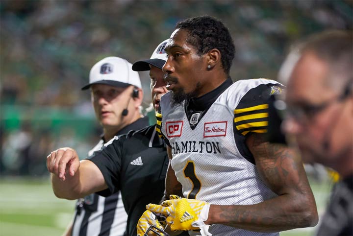 Will Hill #1 of the Hamilton Tiger Cats being escorted from the field after being ejected from the game between the Hamilton Tiger Cats and the Saskatchewan Roughriders at Mosaic Stadium on July 8, 2017 in Regina