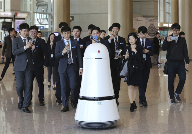 Employees of Incheon International Airport follow Troika, a self-driving robot made by LG Electronics, which moves around for visitors at the Incheon International Airport in Incheon, South Korea. Robots began roaming South Korea's largest airport last summer, helping travelers find their boarding gates and keeping its floors clean.