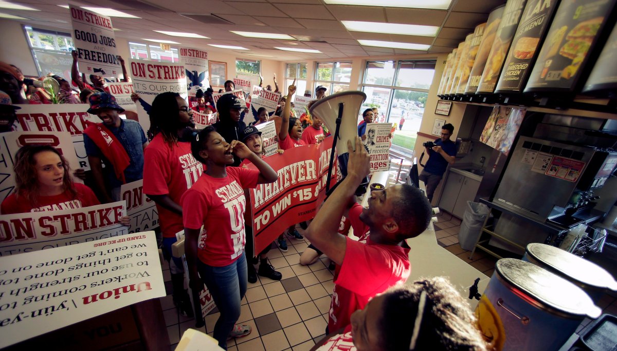 Protesters gather inside a Taco Bell restaurant in Kansas City, Mo. on Thursday, Sept. 4, 2014, as part of the "Fight for $15" campaign, a national protest to push fast-food chains to pay their employees at least $15 an hour. 